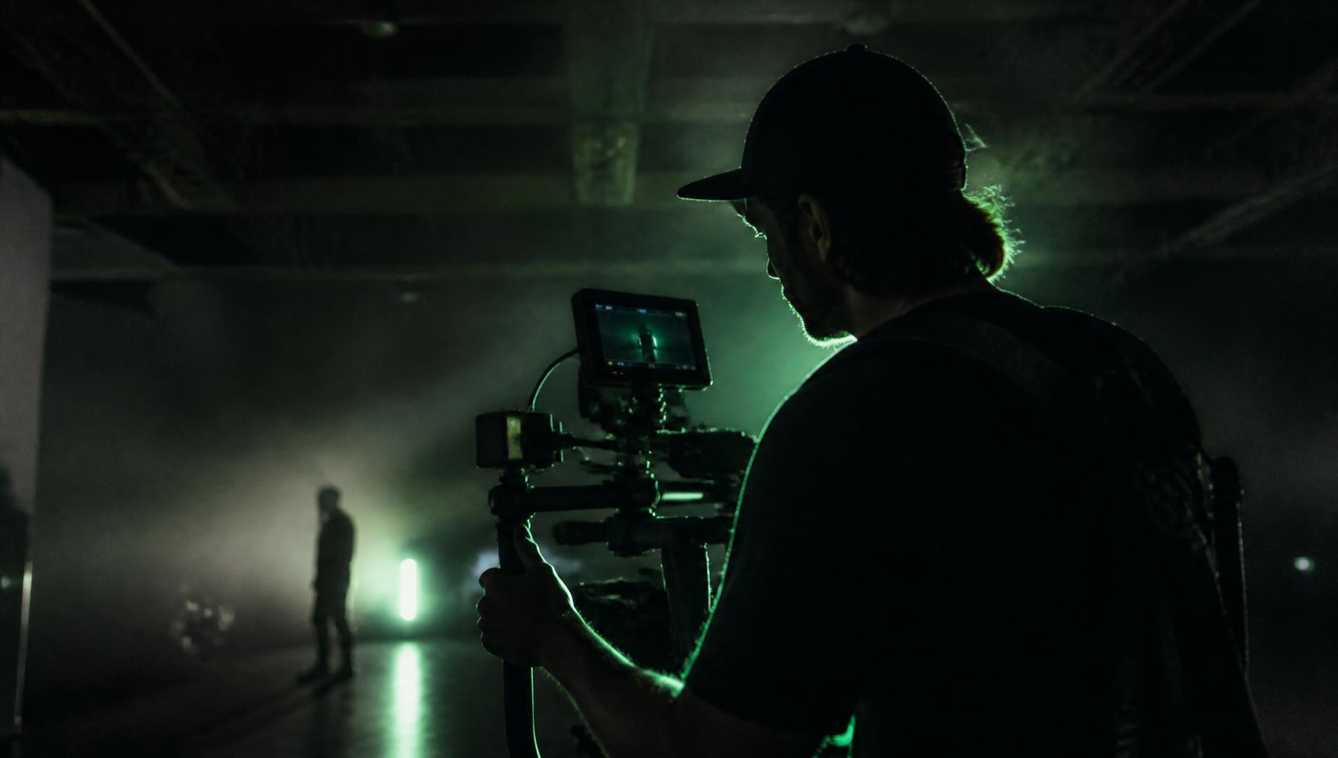 Creator filming on a camera rig in a dark studio